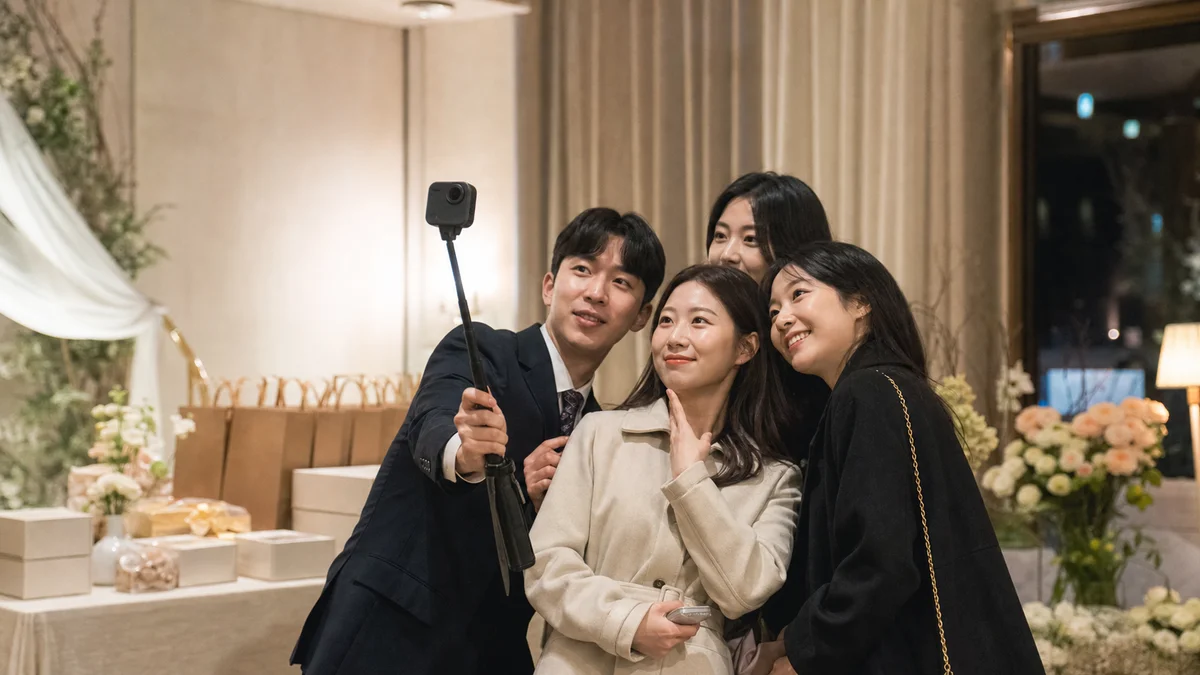결혼식 답례 부스에서 하객들이 360 카메라로 영상을 남기는 모습