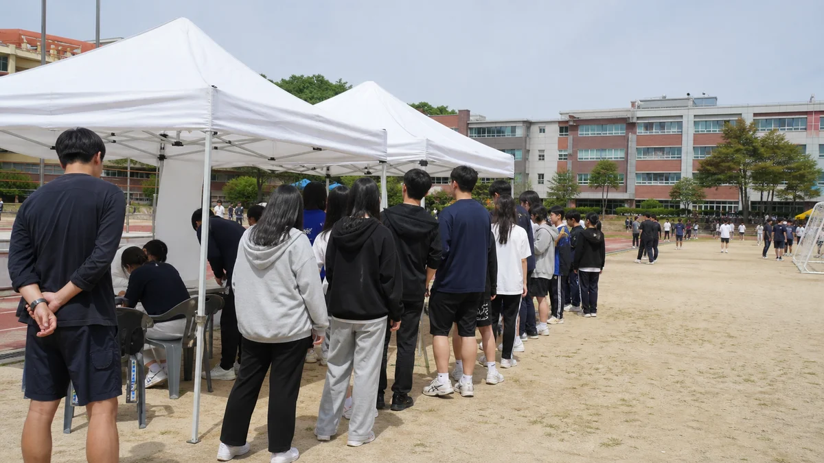 학교 운동회장에 마련된 체험 부스 텐트와 줄 선 학생들