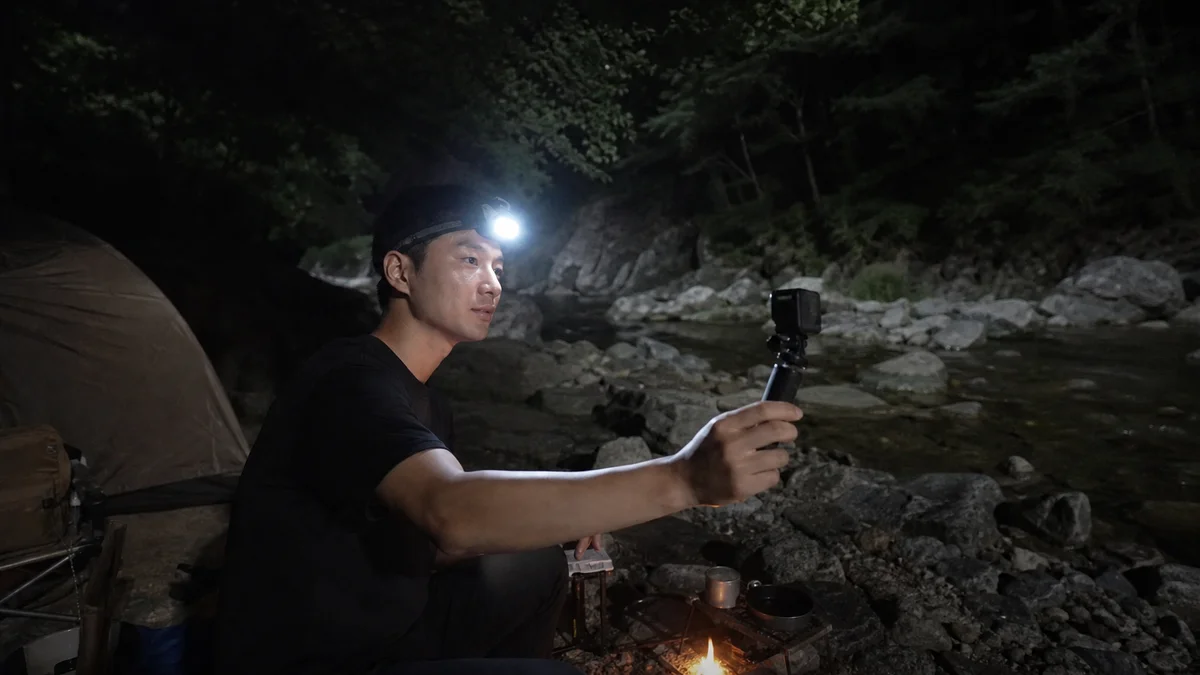 계곡 야영지에서 헤드랜턴을 켜고 액션캠으로 촬영하는 모습